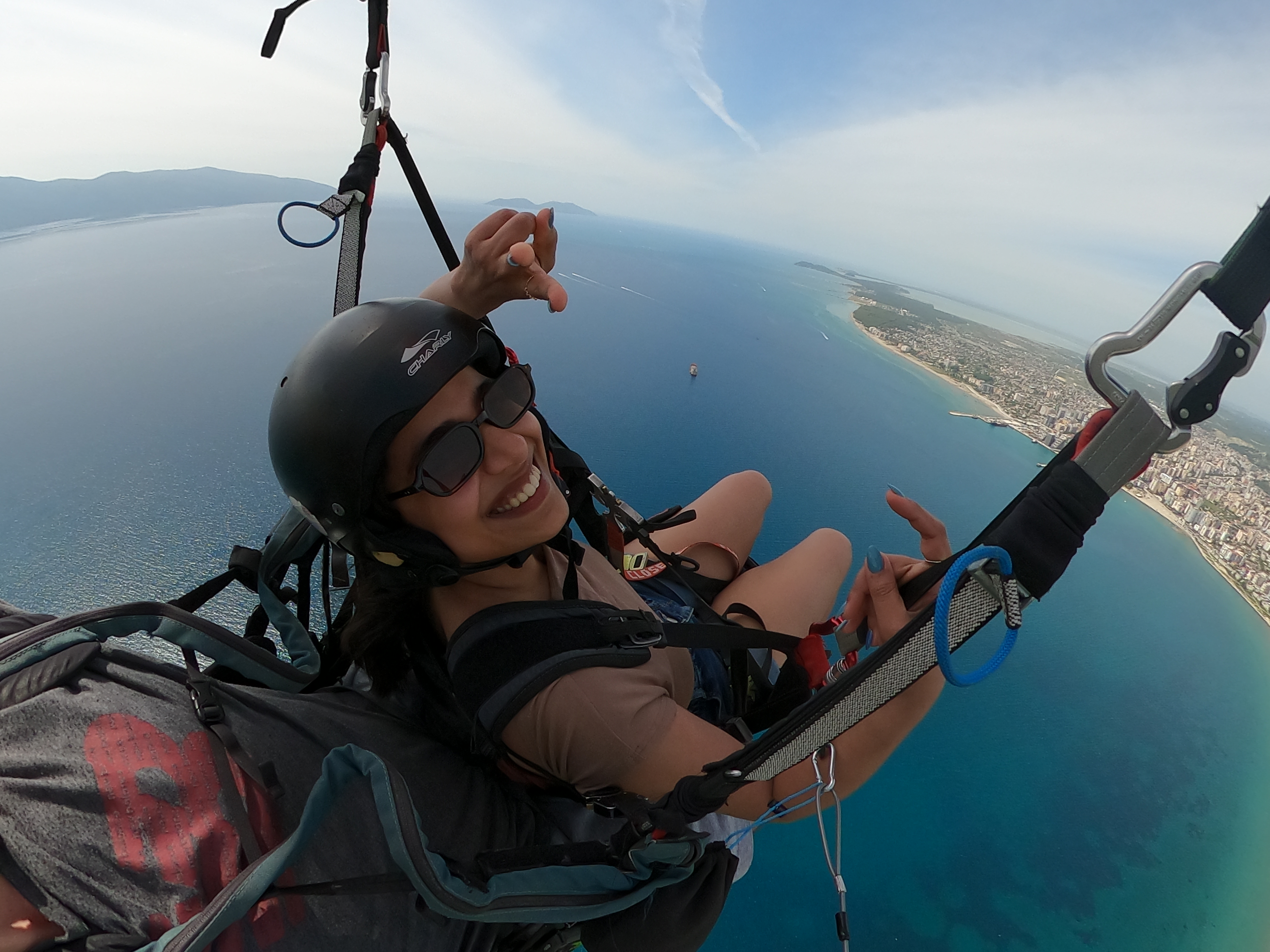 Passenger smiling during paragliding flight above the Albanian Riviera
